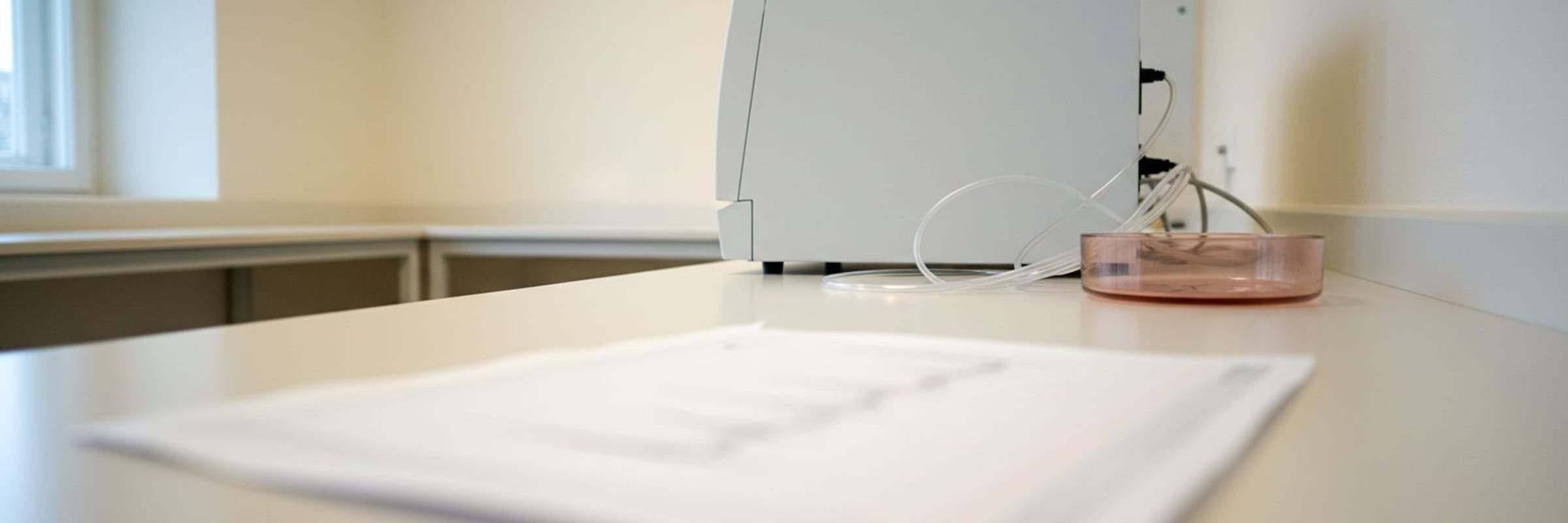 A pale unmarked chromatography bench with a printed chart lying out of focus in the foreground.